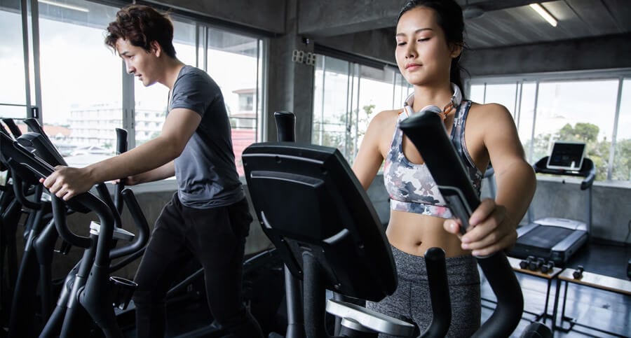 homem e mulher fazendo esteira na academia pensando se deve fazer cardio antes ou depois da musculação